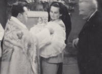 Baptism of daughter Marcela, held by her sister-in-law Vlasta, father Gustav Havlík standing behind her, baptised by parish priest Kocián, Hostinné, 1971