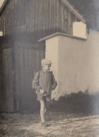 Pavel Veverka on his first school day of in front of his native cottage in Sedlec, 1958