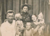 Father Ivan Sevruk holds little Michal in his arms, mother Marie has little Valentina on her lap, elder brother Leonid is between the parents, Vera is standing behind them, 1953