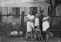 Cousin Anna, parents, brother Jiří, dog Luxa. Jitka Čampulová going to school for the first time, wearing a school bag on her back, 1932