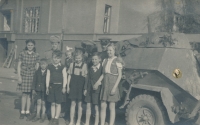 Blanka Lanštiaková (with white ribbon) with other children near a Soviet tank, Prague, 1945