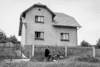 In front of parents' house, cousin's husband Ervin Satke on a motorcycle, 1960s