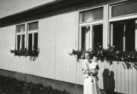 In front of the wooden one-storey building of the boarding house of the nursing institute in Ostrava Zábřeh; a nurse holds Antonie Tichopádová's first daughter Vladimíra in her arms; 1960s