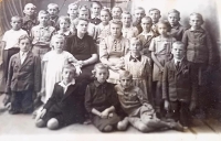 Emílie kneeling in the first row below with black collar, her sister Lída standing third from the left in the top row, Czech school in Huleč Česká, 1st - 3rd class, 1941 - 1944