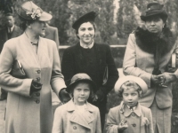 Hana jako dítě vlevo, její matka vlevo ve světlém kabátě za jejími zády