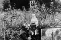 Julie Košťálová se svými syny Leem a Oldřichem před domem na Řečici. Dnes leží toto místo na dně přehrady, jen několik desítek metrů od paty hráze